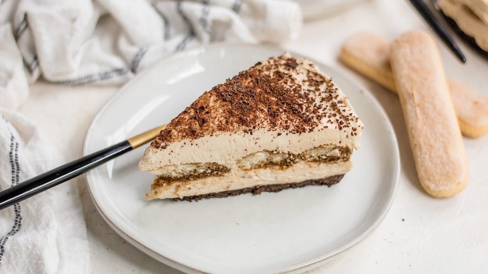 Tiramisu: Strates de biscuits au café et crème mascarpone, saupoudrées de cacao. Une expérience gourmande italienne à savourer. Découvrez notre délice sucré sur le menu.