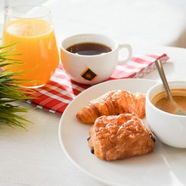 Jus d'orange pressé, boisson chaude, accompagné de votre choix entre un croissant moelleux ou une délicieuse tartine.